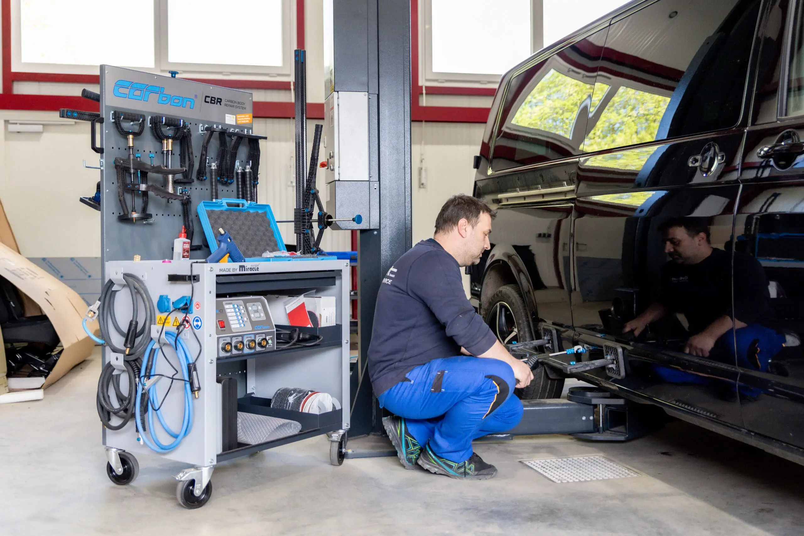 Mitarbeiter fährt Smart Repair an einem Fahrzeug durch, um kleinere Unfallschäden präzise zu beheben.